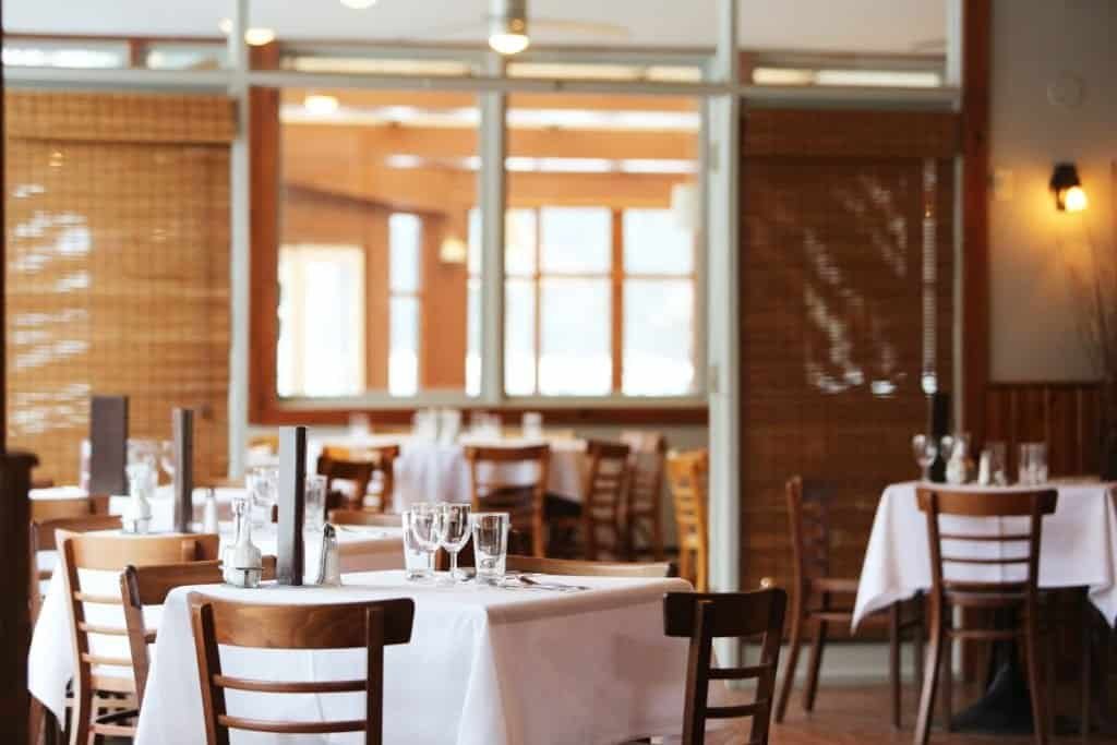 Person browsing a restaurant website on a mobile phone while at a table